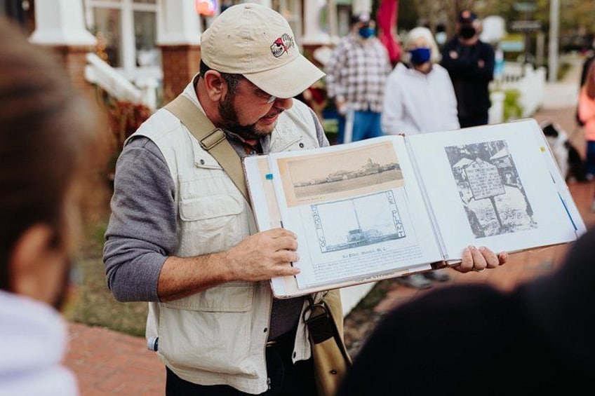 A person holding a book with maps and diagrams. 1