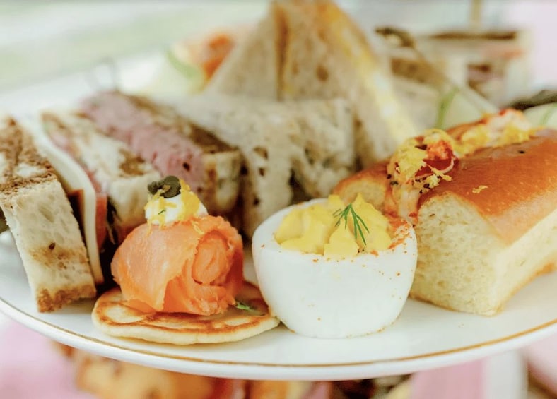 A plate of food with various items including bread, eggs, and a piece of salmon. 2
