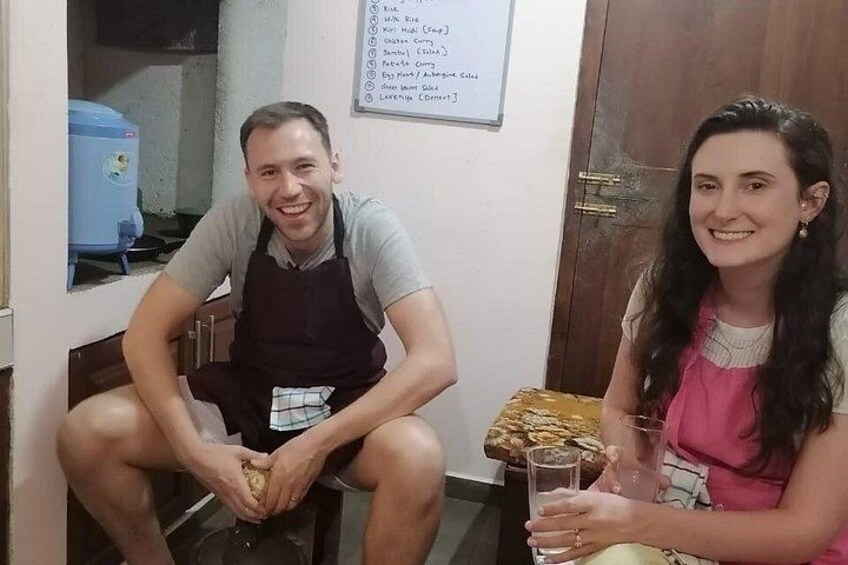 Two people sitting at a table with a menu and a blue appliance in the background. 2
