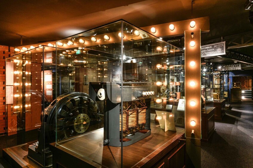 A museum exhibit with a large, illuminated display case containing vintage electrical equipment. 3