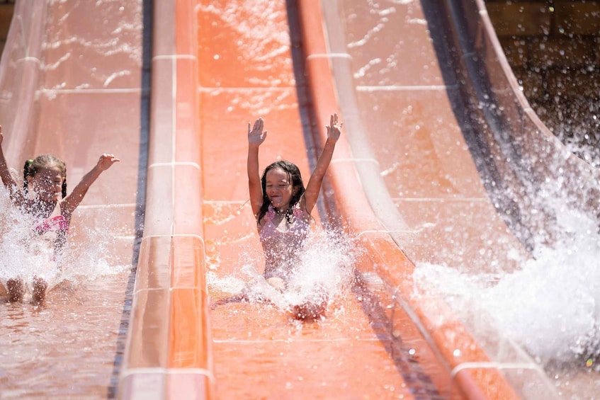 Children sliding down a water slide. 5