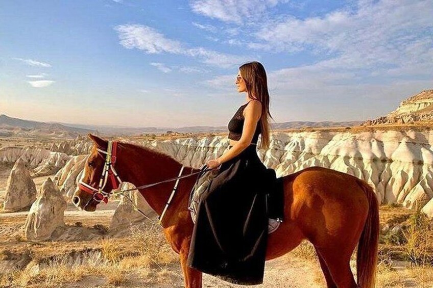Una persona montando a caballo en un paisaje desértico con formaciones rocosas blancas. 4