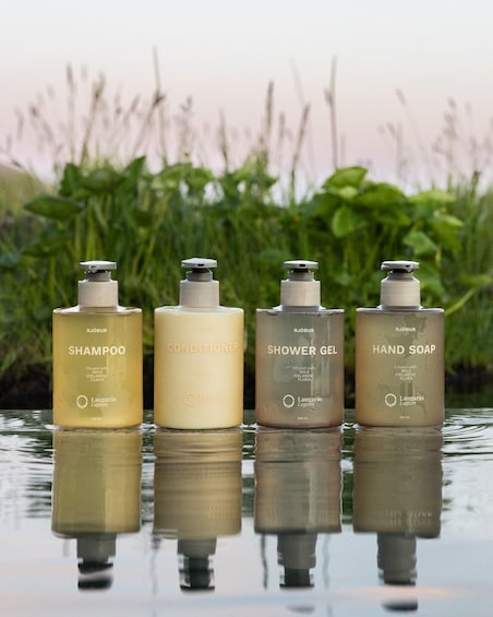 Four bottles of Laugaras Lagoon products on a reflective surface with a natural background. 2