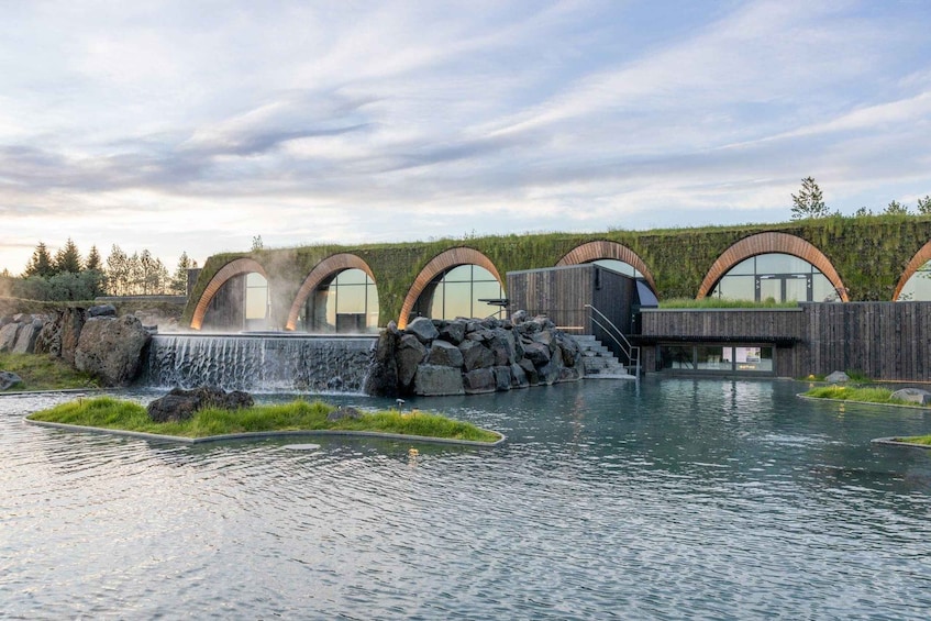 A modern building with arched windows and a water feature. 4