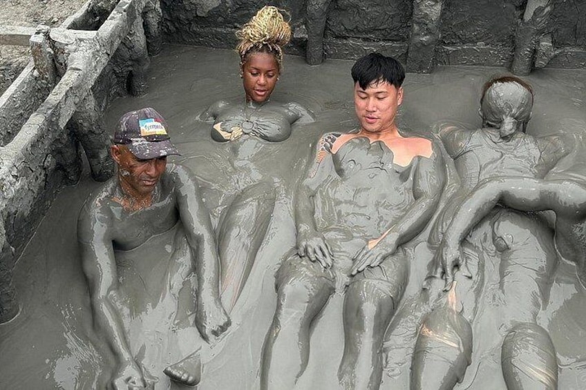 People in a natural, muddy water body with rocky surroundings. 3