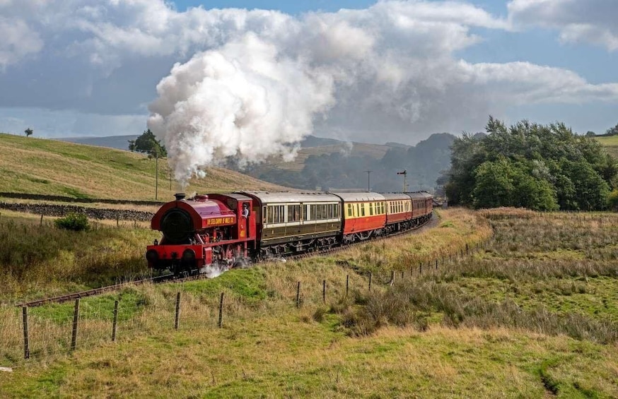 A steam locomotive pulling passenger cars through a rural landscape with hills and sparse vegetation. 1