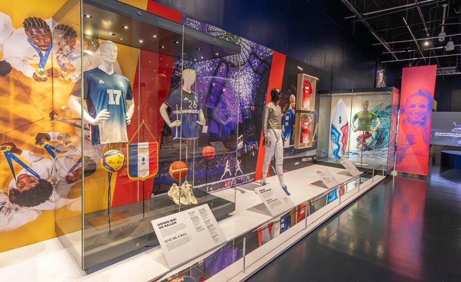 Una exhibición de recuerdos deportivos con camisetas, una pelota de baloncesto y una tabla de surf. 2