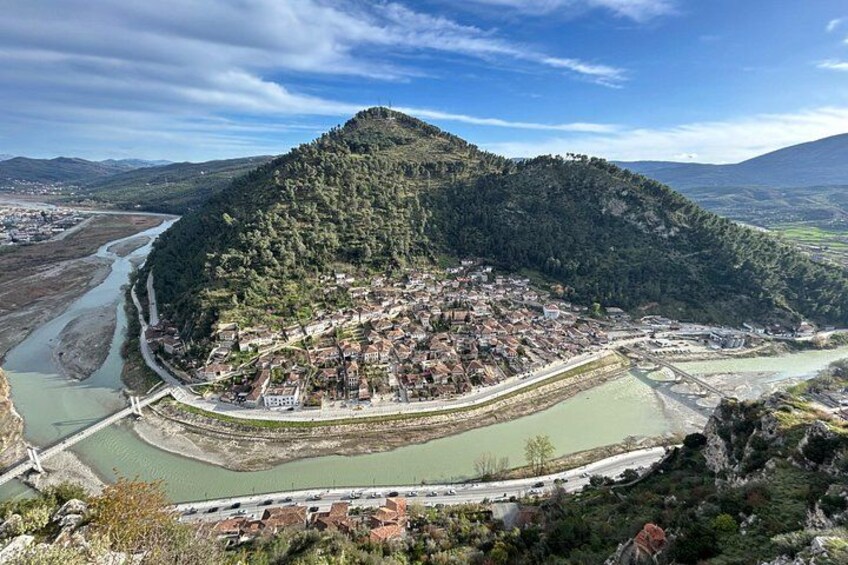 A town nestled in a valley with a river, surrounded by hills. 5
