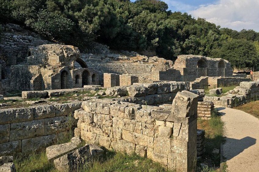 Ancient ruins with stone structures and a pathway. 4