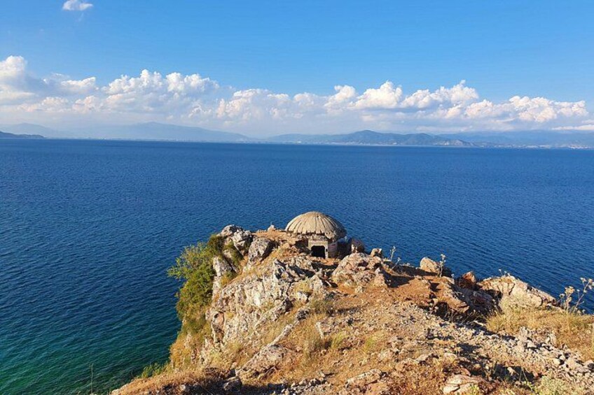 A coastal landscape with a rocky outcrop and a small dome-like structure. 2
