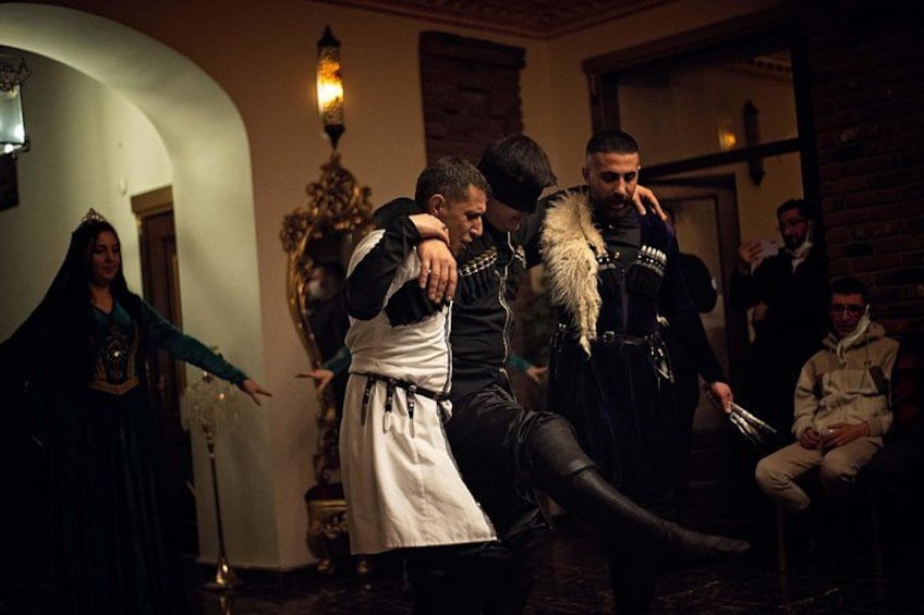 A historical reenactment with participants in period costumes, a chandelier, and a brick wall. 2