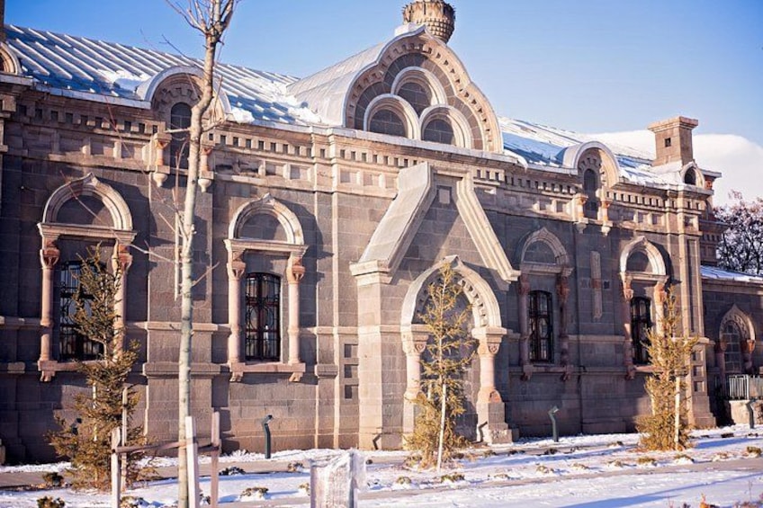 A historic building with arched windows and a snow-covered roof. 5