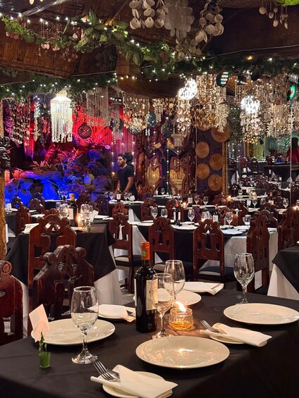 A restaurant with ornate decorations, wooden furniture, and tables set for dining. 2