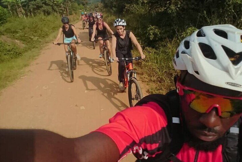 A group of cyclists on a dirt path surrounded by greenery. 1
