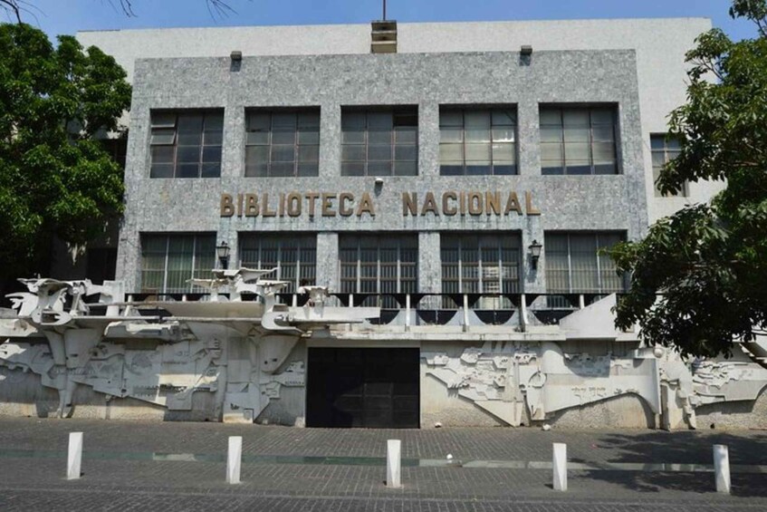 A building labeled 'Biblioteca Nacional' with a stone facade and a bridge with sculptures in front. 4