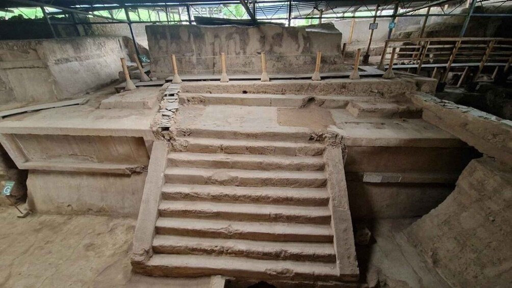 An ancient stone structure with a central staircase leading to an upper level. 2
