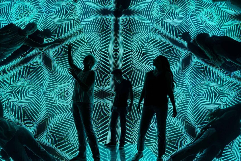 A group of people standing in front of a geometric light pattern. 2