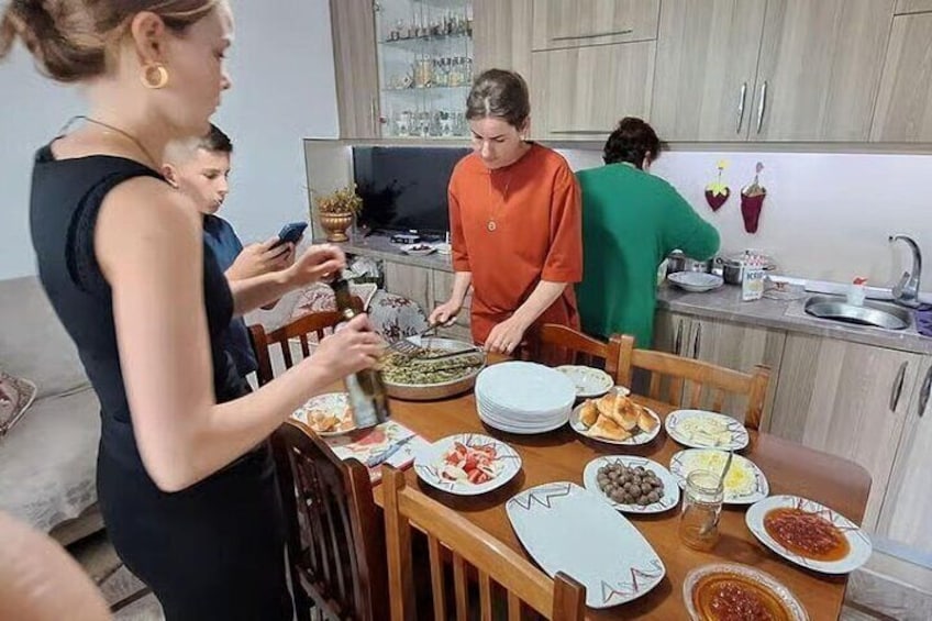 Una famiglia cena in cucina, con un tavolo ricco di piatti. 1