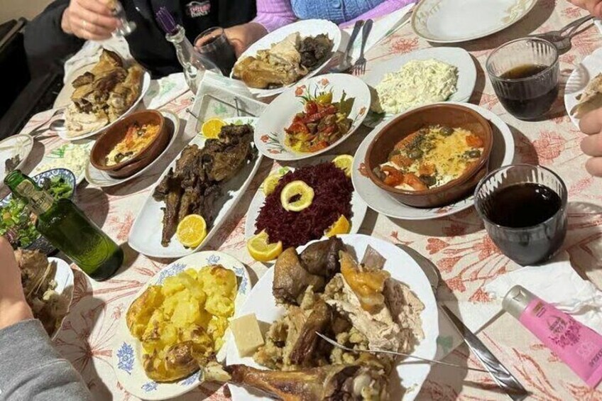 Un tavolo imbandito con diversi piatti, tra cui carni arrosto, insalate e pane. 2