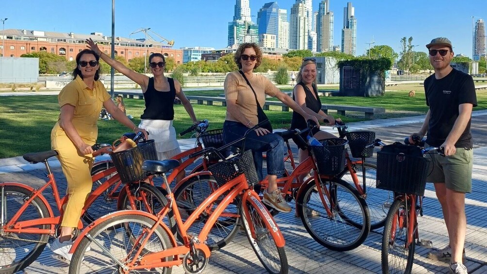 Un grupo de personas en bicicleta en un parque urbano, con un horizonte de la ciudad al fondo. 4