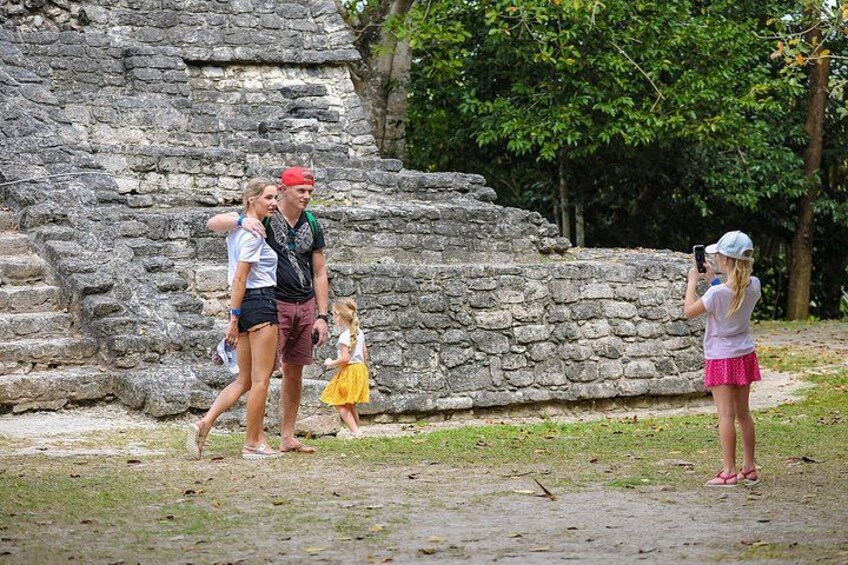 Un groupe de personnes se trouve près d’anciennes ruines de pierre, et l’une d’entre elles prend une photo. 2
