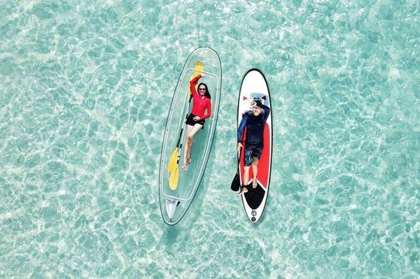 Two people on paddleboards in clear turquoise water. 1