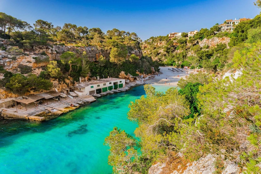 A coastal landscape with clear turquoise waters, rocky cliffs, and lush greenery. 4
