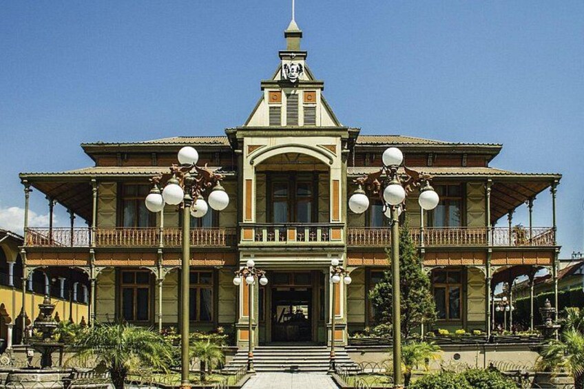 A large, ornate building with a central entrance, balconies, and decorative street lamps. 5