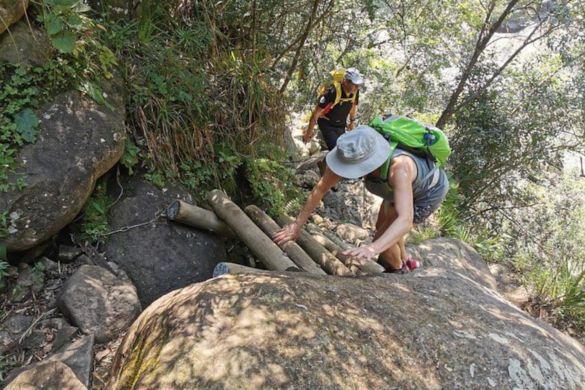 A person climbing a rocky path with a backpack. 3