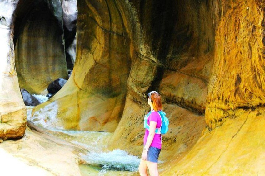 A person hiking near a river in a rocky canyon. 1