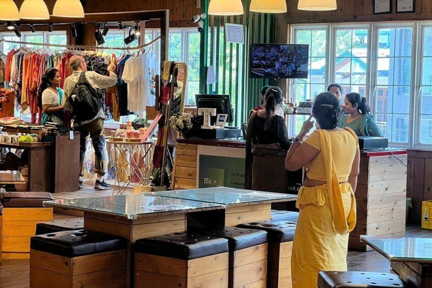 A clothing store with racks of clothes, a counter, and a TV screen. 5