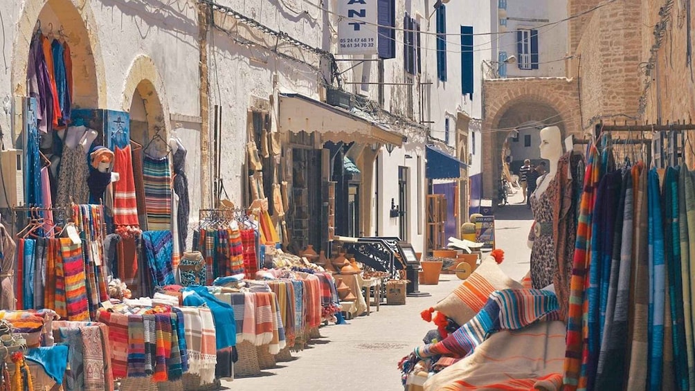A bustling market with colorful textiles and clothing stalls. 5