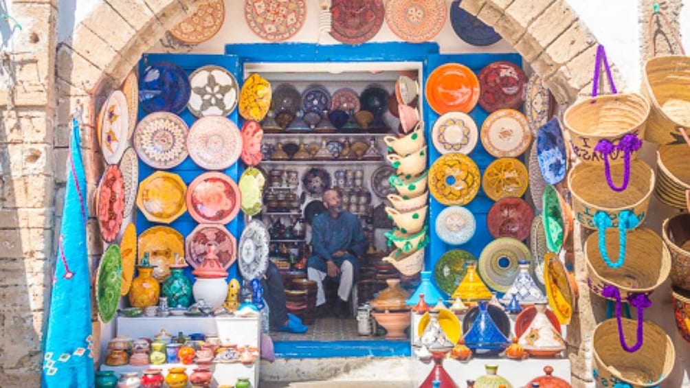 A shop with colorful plates and pottery displayed outside. 4