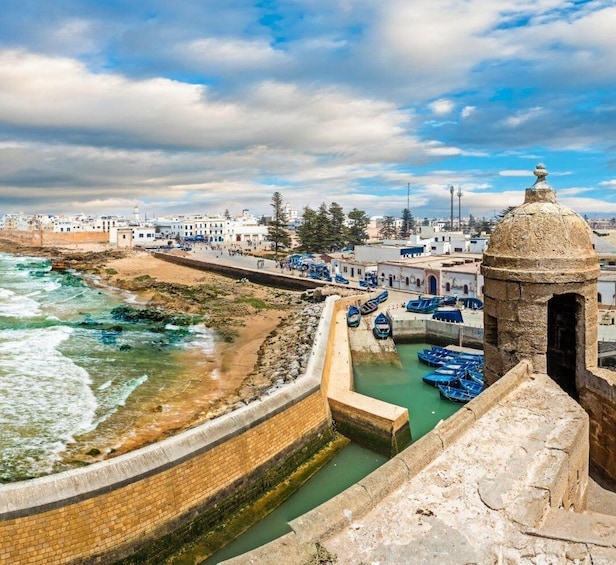 A coastal town with a sea wall, boats, and traditional architecture. 2