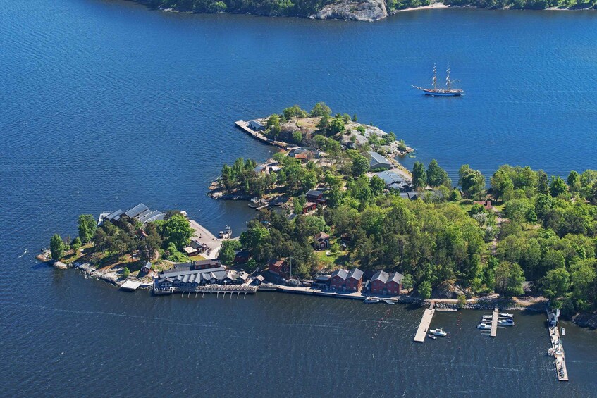 An aerial view of a coastal area with multiple small islands, docks, and a sailboat. 2