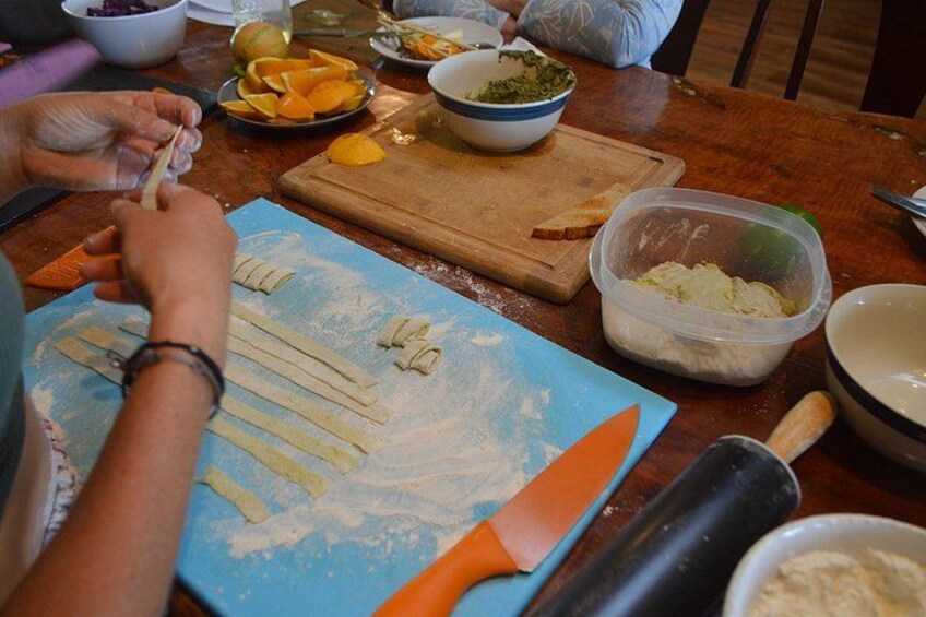 A person preparing food with ingredients and utensils on a table. 2
