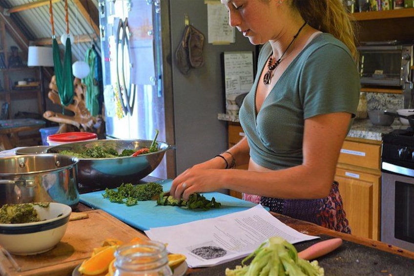 A person chopping vegetables on a cutting board in a kitchen. 4