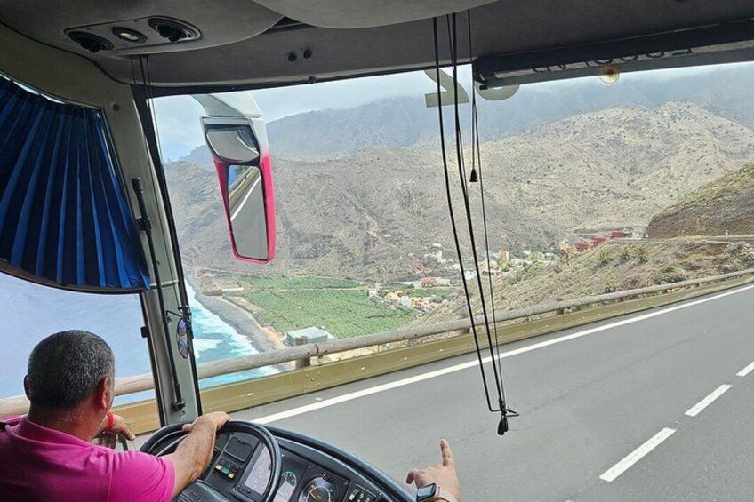 A vehicle driving on a road with a mountainous landscape in the background. 4