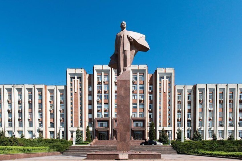 A statue in front of a row of modern apartment buildings. 1
