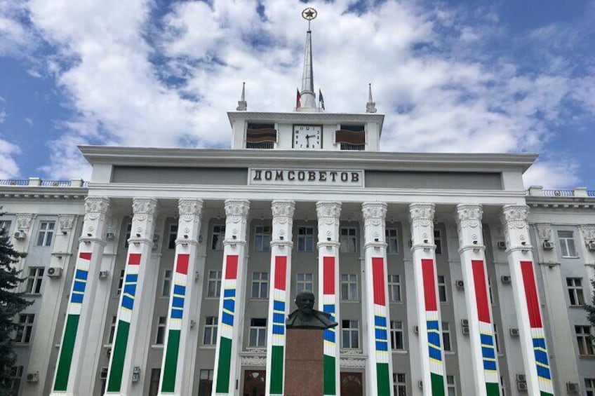A building with columns, a clock, and a flag. 2