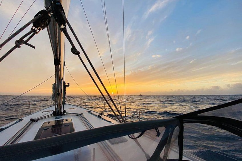 Le pont d’un voilier, avec ses cordages, et un coucher de soleil sur l’océan. 5