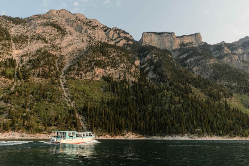 Un bateau sur une rivière, avec une montagne boisée en arrière-plan. 3