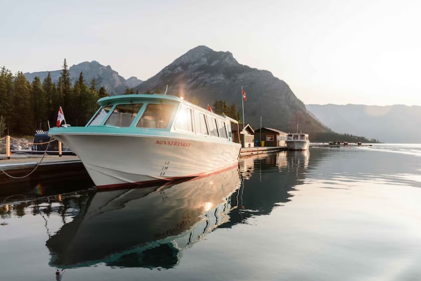 Un bateau nommé MINNERMANNAI a accosté dans une marina, avec une chaîne de montagnes en toile de fond. 5