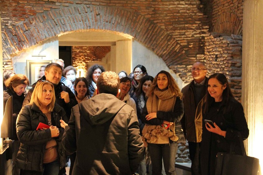 A group of people standing in a stone archway. 2