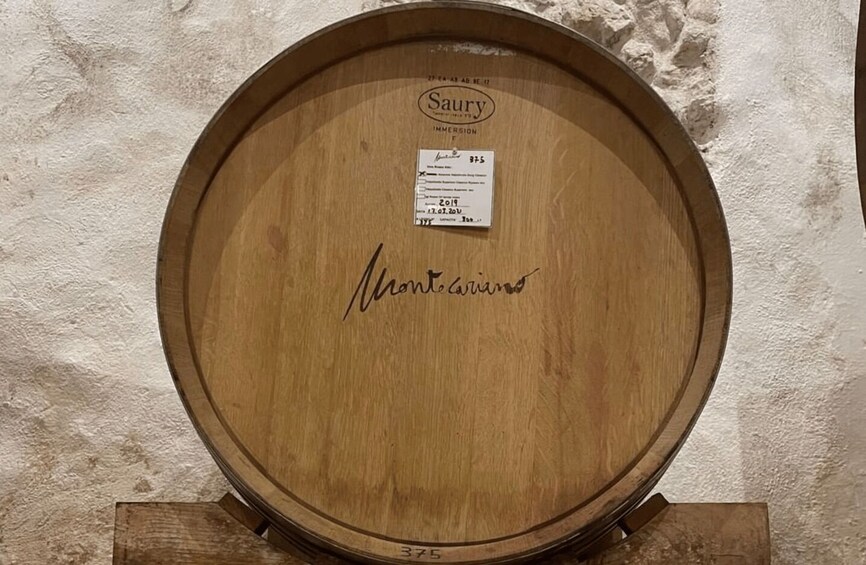 A wooden barrel with a label and signature. 4