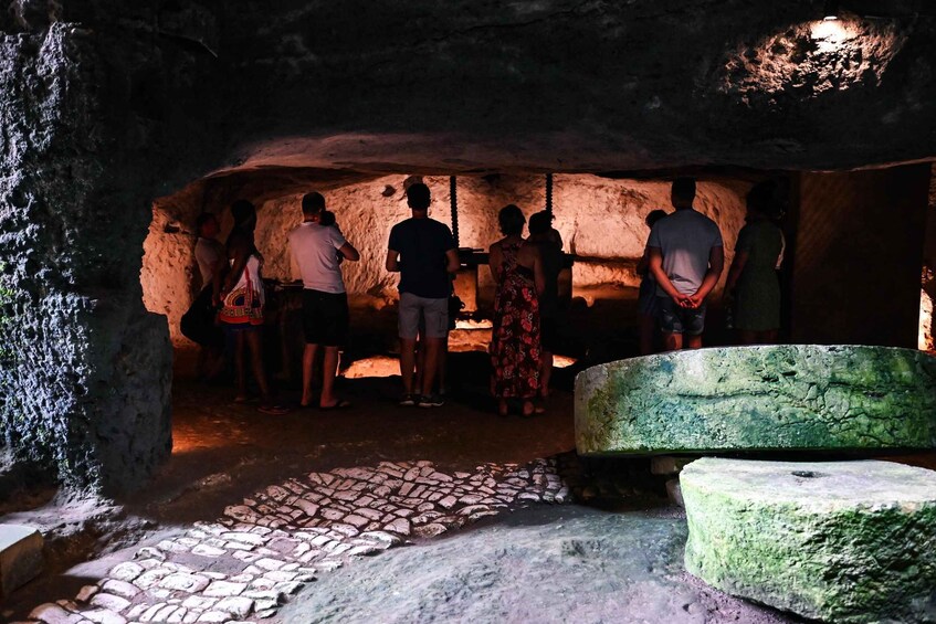 A group of people inside a cave with a fire at the back. 5