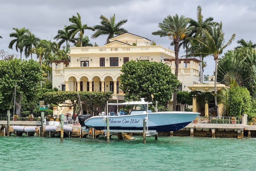 A boat docked at a marina with a large building and palm trees in the background. 4