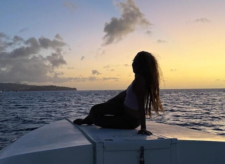 Una persona sentada al borde de un bote durante el atardecer. 3