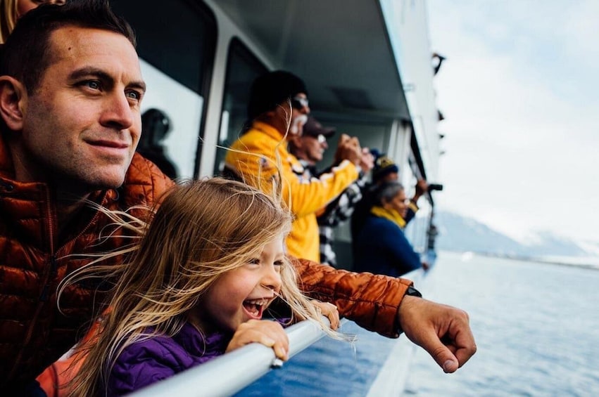 A group of people on a boat, with a child in the foreground and adults in the background. 4