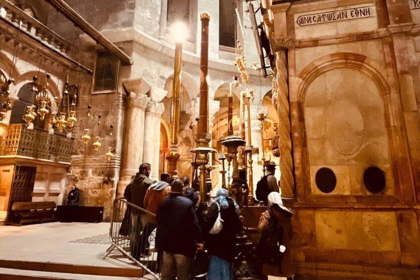 An interior of a historical building with people, ornate chandeliers, and a large arched doorway. 2